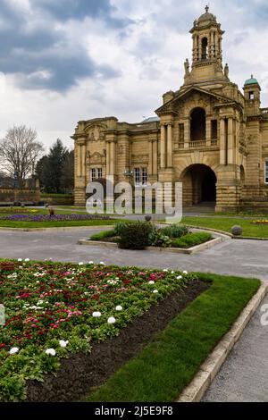 Cartwright Memorial Hall: Außenansicht der Bürgerkunstgalerie (großes historisches Gebäude) & helle Blumen auf den Betten - landschaftlich reizvoller Lister Park, Bradford, England, Großbritannien. Stockfoto