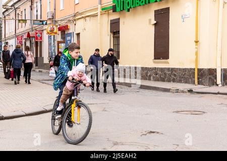 Sambir, Ukraine. 22. April 2022. Ukrainische Kinder fahren am 22. April 2022 an einem orthodoxen Karfreitag in Sambir, Oblast Lemberg, Ukraine, auf einem Hauptmarkt mit dem Fahrrad. Als die Russische Föderation vor fast zwei Monaten in die Ukraine einmarschierte, hatte der Konflikt Auswirkungen auf alle Gebiete des Landes. Dennoch gilt die westliche Ukraine mit ihrer Region Lemberg als sicherer Himmel im Vergleich zum östlichen Teil des Landes. (Foto von Dominika Zarzycka/Sipa USA) Quelle: SIPA USA/Alamy Live News Stockfoto