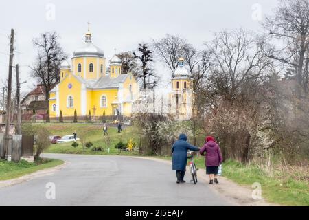 Sambir, Ukraine. 22. April 2022. Ukrainische Frauen gehen am 22. April 2022 an einem orthodoxen Karfreitag in Nadyby, Oblast Lwiw, Ukraine, vor eine orthodoxe Kirche. Als die Russische Föderation vor fast zwei Monaten in die Ukraine einmarschierte, hatte der Konflikt Auswirkungen auf alle Gebiete des Landes. Dennoch gilt die westliche Ukraine mit ihrer Region Lemberg als sicherer Himmel im Vergleich zum östlichen Teil des Landes. (Foto von Dominika Zarzycka/Sipa USA) Quelle: SIPA USA/Alamy Live News Stockfoto