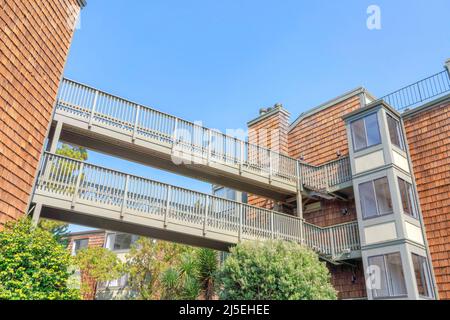 Zwei Fußgängerbrücken, die zwei Mehrfamilienhäuser mit Holzschindelsidges in San Francisco, CA, verbinden Stockfoto