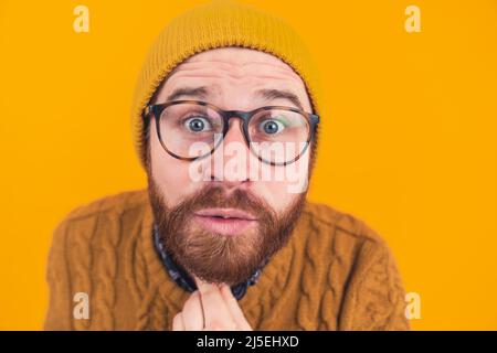 Nahaufnahme eines überraschten, glücklichen jungen Geschäftsmannes in einer Brille mit der Hand am Kinn. Hochwertige Fotos Stockfoto