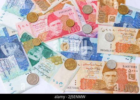 Pakistanische Papiergeldscheine mit Münzen Stockfoto