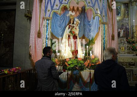 Pagani, Salerno, Italien - 22. April, 2022 :die Statue der Muttergottes wird während des Festes der Santa Maria Incoronata del Carmine, der sogenannten "delle Galline", in einer Reihe von Gläubigen Ansichten dargestellt.Es handelt sich um ein religiöses und ziviles Ereignis, das jährlich von Freitag, dem achten Ostern, bis zum folgenden Montag in Pagani (Salerno) stattfindet. Das Fest, das im gleichnamigen Heiligtum gefeiert wird, wird von den Karmeliten des Heiligtums selbst und von der Erzbruderschaft der Madonna delle Galline organisiert. Die Tradition erzählt von einem Gemälde, das das Bild der Madonna darstellt, das von einigen Hühnern gefunden wurde, während sie kratzten Stockfoto