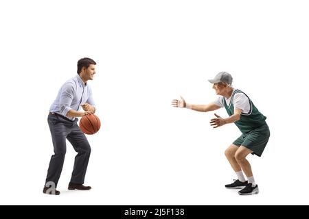 Junger Mann in formeller Kleidung und älterer Mann in Sporttrikot, der auf weißem Hintergrund isoliert Basketball spielt Stockfoto