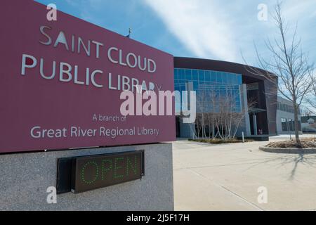 SAINT CLOUD, MINNESOTA - 19. Februar 2022: Das Schild der Saint Cloud Public Library ist mit dem Bibliotheksgebäude im Hintergrund fotografiert. Stockfoto