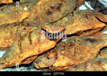Ein Haufen gebratener Nil Tilapia Fische Oreochromis niloticus in der Fritteuse gebraten, mit einer Mischung aus Knoblauchsauce, Zitrone, Fischsalz und Gewürzen a zubereitet Stockfoto