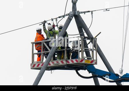 Bridgwater, Somerset, Großbritannien. 23.. April 2022. Arbeiter auf einer Luftplattform, die an einem der neuen National Grid T-Masten in Bridgwater in Somerset arbeitet, die als Teil des Hinkley Point C über die Somerset-Ebenen gebaut wurden.Bildquelle: Graham Hunt/Alamy Live News Stockfoto