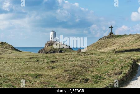 Blick auf den Leuchtturm von TWR Mawr von der Spitze von Llanddwyn Island, Anglesey, North Wales, Großbritannien. Aufgenommen am 3.. April 2022. Stockfoto