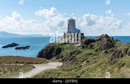 Blick auf den Leuchtturm von TWR Mawr von der Spitze von Llanddwyn Island, Anglesey, North Wales, Großbritannien. Aufgenommen am 3.. April 2022. Stockfoto
