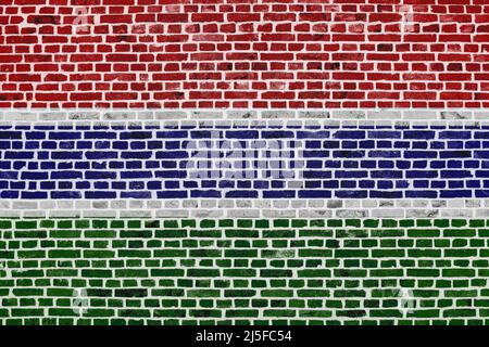 Nahaufnahme einer Ziegelmauer mit der Flagge von Gambia. Stockfoto