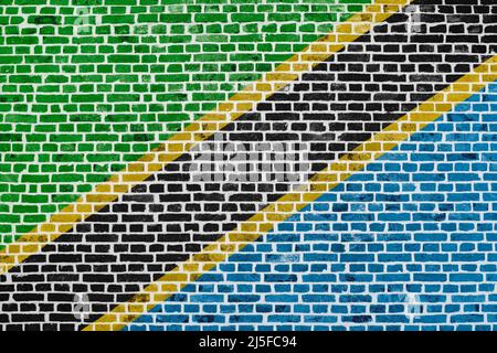 Nahaufnahme einer Backsteinmauer mit der Flagge Tansanias. Stockfoto