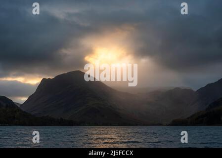 Atemberaubendes Landschaftsbild von Buttermere im Lake District bei Sonnenaufgang im Herbst mit dramatischem stürmischen Himmel Stockfoto