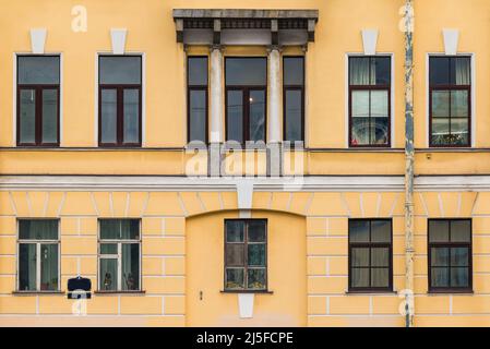 Viele Fenster in einer Reihe auf der Fassade des städtischen historischen Mehrfamilienhauses Vorderansicht, Sankt Petersburg, Russland Stockfoto