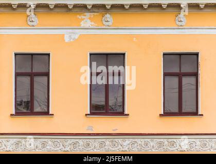 Drei Fenster in einer Reihe auf der Fassade des städtischen historischen Mehrfamilienhauses Vorderansicht, Sankt Petersburg, Russland Stockfoto