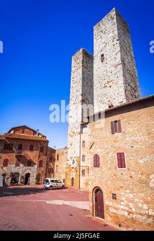 San Gimignano, Italien. Piazza delle Erbe und Torri dei Salvucci, berühmte kleine mittelalterliche Stadt mit Mauern im Landkreis Siena, Toskana. Bekannt als Stockfoto