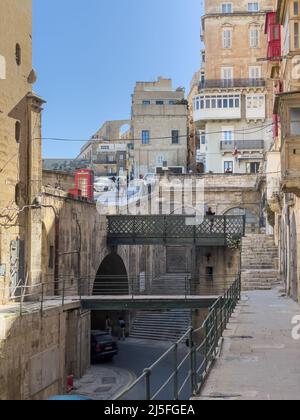 Valletta, Malta - April 8. 2022: Das Ende der Straße mit dem Victoria Gate und den terrassenförmigen Bögen der Upper Barrakka Gardens im Hintergrund. Stockfoto