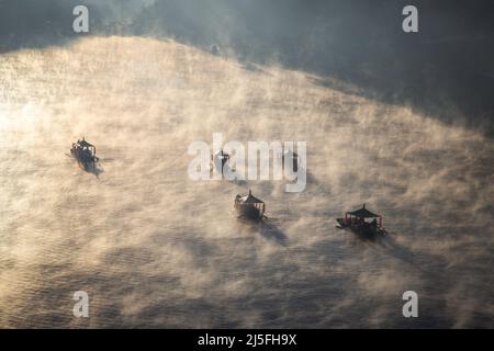 Sonnenaufgang mit Nebel über Ban Rak thai, chinesisches Dorf in der Nähe eines Sees in Mae Hong Son, Thailand Stockfoto