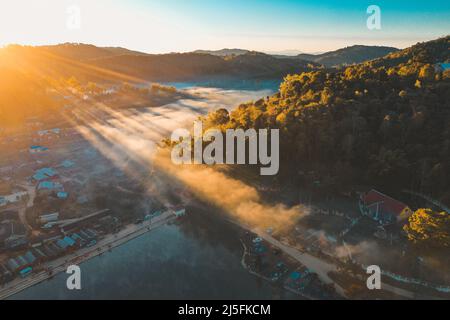 Luftaufnahme des Sonnenaufgangs mit Nebel über Ban Rak thai, chinesisches Dorf in der Nähe eines Sees in Mae Hong Son, Thailand Stockfoto