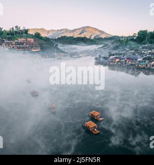 Luftaufnahme des Sonnenaufgangs mit Nebel über Ban Rak thai, chinesisches Dorf in der Nähe eines Sees in Mae Hong Son, Thailand Stockfoto