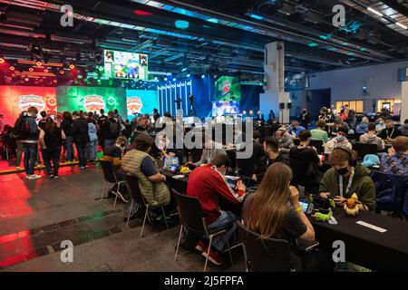 Frankfurt, Deutschland. 23. April 2022. 23. April 2022, Hessen, Frankfurt/Main: Besucher spielen Pokemon bei den Pokemon Europe Championships. Nach einer mehrjährigen Unterbrechung finden wieder die Pokemon Europe International Championships statt. Die Spiele werden mit Handelskarten, auf Videospielkonsolen und Mobiltelefonen gespielt. Bei Pokemon geht es darum, die Monster zu sammeln und zu trainieren. Auch in den Frankfurter Messehallen waren die Zuschauer erlaubt. Foto: Hannes P. Albert/dpa Quelle: dpa picture Alliance/Alamy Live News Stockfoto