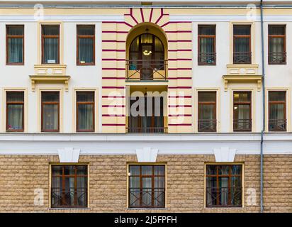 Zwei Balkone und viele Fenster in einer Reihe auf der Fassade des modernen städtischen Wohnhauses Vorderansicht, Krasnaya Polyana, Sotschi, Region Krasnodar, Russ Stockfoto