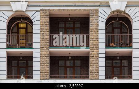 Mehrere Balkone und Fenster in einer Reihe auf der Fassade des modernen städtischen Wohnhauses Vorderansicht, Krasnaya Polyana, Sotschi, Krasnodar Region, Russi Stockfoto