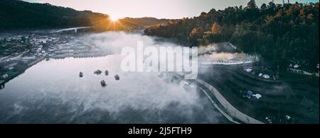 Luftaufnahme des Sonnenaufgangs mit Nebel über Ban Rak thai, chinesisches Dorf in der Nähe eines Sees in Mae Hong Son, Thailand Stockfoto