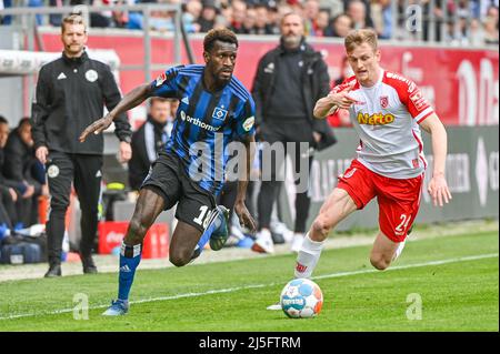 Regensburg, Deutschland. 23. April 2022. Fußball: 2. Bundesliga, Jahn Regensburg - Hamburger SV, Matchday 31, Jahnstadion Regensburg. Scott Kennedy aus Regensburg (r) kämpft mit Bakery Jatta aus Hamburg um den Ball. Quelle: Armin Weigel/dpa - WICHTIGER HINWEIS: Gemäß den Anforderungen der DFL Deutsche Fußball Liga und des DFB Deutscher Fußball-Bund ist es untersagt, im Stadion und/oder vom Spiel aufgenommene Fotos in Form von Sequenzbildern und/oder videoähnlichen Fotoserien zu verwenden oder zu verwenden./dpa/Alamy Live News Stockfoto