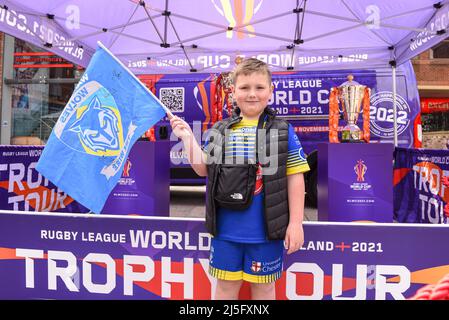 Ein junger Fan von Warrington Wolves posiert vor dem Spiel in der Fanzone neben den Rugby League World Cup Trophies für Fotos Stockfoto