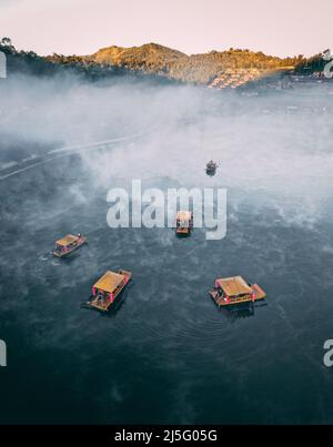 Luftaufnahme des Sonnenaufgangs mit Nebel über Ban Rak thai, chinesisches Dorf in der Nähe eines Sees in Mae Hong Son, Thailand Stockfoto