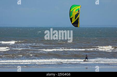 Portobello, Edinburgh, Schottland, Großbritannien. 23.. April 2022. Kitesurfer auf dem Firth of Forth in Porty, ungewöhnlich für Kitesurfen hier, aber aufgrund des Windes, der von ENE 31km/h mit Böen potenziell 42 km/h und einer Temperatur von 12 Grad eintraf, gab es ideale Bedingungen für ein paar Kitesurfer, um auf die raue Oberfläche zu kommen. Stockfoto