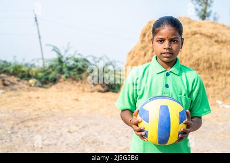 Sweat Village Teenager-Mädchen mit Fußball in der Nähe von Reisfeld nach dem Spielen mit Kopieplatz - Konzept von Urlaub, Hobbys und Aspiration Stockfoto