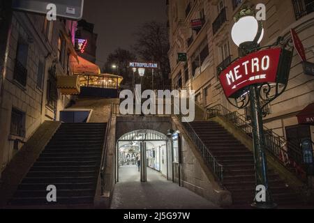 Paris, Frankreich: Nachtansicht, Straßenlaternen und Neonschilder am Eingang der Montmartre Metrostation, berühmter Hügel im nördlichen 18. Arrondissement Stockfoto