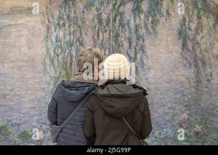 Paris, Frankreich, Europa: Besucher vor den Nympheas (Seerosen), einer berühmten Serie von dekorativen Tafeln von Claude Monet im Musée de l'Orangerie Stockfoto