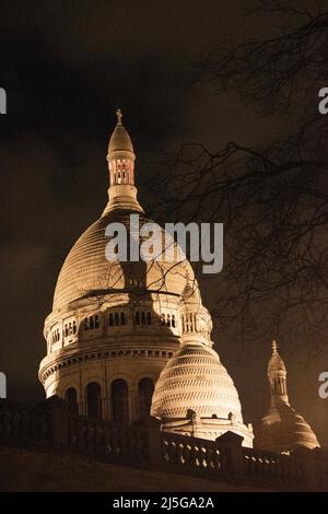 Paris, Frankreich: Nachtansicht der Basilica of the Sacred Heart, der berühmten römisch-katholischen Kirche, die von Paul Abadie auf dem Gipfel des Montmartre-Hügels entworfen wurde Stockfoto