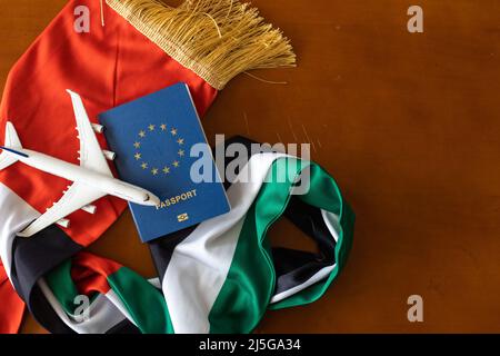 Reisepass und eine Flagge der Vereinigten Arabischen Emirate auf einem hölzernen Hintergrund. Reisekonzept. Stockfoto