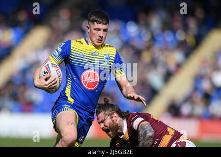 Riley Dean #27 von Warrington Wolves läuft an Chris McQueen #12 von Huddersfield Giants vorbei Stockfoto