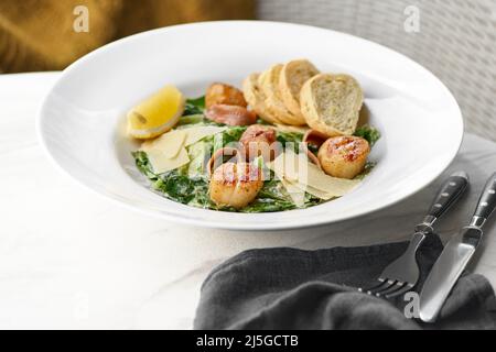 Gourmet-Gericht – Weißteller mit gegrilltem Jakobsmuscheln. Jakobsmuscheln mit Gemüse und cremigem Espuma. Köstliche Meeresfrüchte auf der Speisekarte des Restaurants Stockfoto