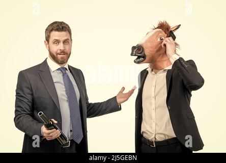 Betrunkener Geschäftsmann zeigt auf hart arbeitendem Mann im Pferdekopf, der auf der Party telefoniert, workaholic Stockfoto