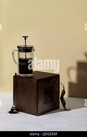Kaffee-Hintergründe. Frischer Kaffee in der französischen Presse. Heller Hintergrund. Stockfoto