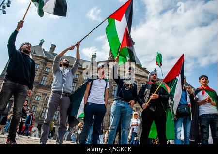 Junge palästinensische Männer schwenken während der Demonstration palästinensische Fahnen. Hunderte von Menschen versammelten sich auf dem Dam-Platz in Amsterdam, um ihre Unterstützung für Palästina zu zeigen und die jüngste Gewalt der israelischen Regierung gegen Palästinenser anzuprangern. Der „Notfallprotest“ wurde als Reaktion auf die jüngste Aggression Israels gegen Palästinenser am 15. April in der Al-Aqsa Moschee in Jerusalem organisiert. Mehr als 150 Palästinenser wurden verletzt, als sie Steine und Feuerwerke warfen und israelische Streitkräfte Elektroschockgranaten und Tränengas abfeuerten. Stockfoto