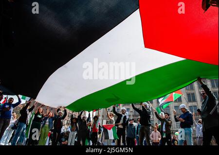 Ein Blick von unten auf eine riesige palästinensische Flagge während der Demonstration. Hunderte von Menschen versammelten sich auf dem Dam-Platz in Amsterdam, um ihre Unterstützung für Palästina zu zeigen und die jüngste Gewalt der israelischen Regierung gegen Palästinenser anzuprangern. Der „Notfallprotest“ wurde als Reaktion auf die jüngste Aggression Israels gegen Palästinenser am 15. April in der Al-Aqsa Moschee in Jerusalem organisiert. Mehr als 150 Palästinenser wurden verletzt, als sie Steine und Feuerwerke warfen und israelische Streitkräfte Elektroschockgranaten und Tränengas abfeuerten. (Foto von Ana Fernandez/SOPA Images/Sipa USA) Stockfoto