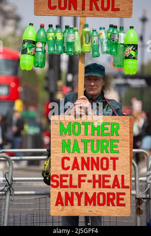 London, Großbritannien. 23. April 2022. Ein Mann, der Plakate mit leeren Flaschen hält, steht an der Ecke des Parliament Square und protestiert gegen die Verwendung von Plastikflaschen. Kredit: SOPA Images Limited/Alamy Live Nachrichten Stockfoto