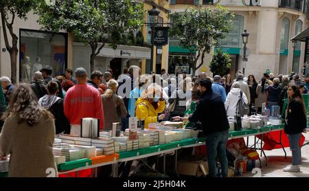 Palma, Spanien. 23. April 2022. Touristen und Einheimische gehen am St. George's Day neben Buchhändlern in der Carrer Colom Straße in Palma de Mallorca. Der 23. April wird weltweit am Buchtag gefeiert, und auf Mallorca ist es typisch für Bibliotheken, ihre Stände in den Hauptstraßen einzurichten. Quelle: Clara Margais/dpa/Alamy Live News Stockfoto