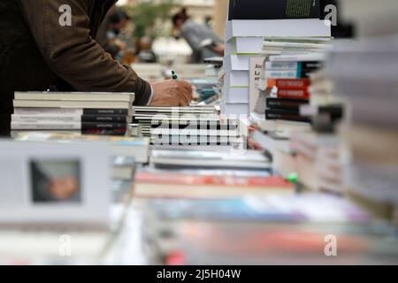 Palma, Spanien. 23. April 2022. Ein Mann signiert ein Buch in der Straße Sant Miquel in Palma de Mallorca während des Tages von St. George. Der 23. April wird weltweit zum Tag des Buches gefeiert, auf Mallorca ist es typisch, dass die Bibliotheken ihre Stände in den Hauptstraßen aufrichten. Quelle: Clara Margais/dpa/Alamy Live News Stockfoto