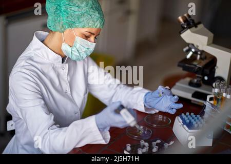 Laborarbeiterin, die mit Chemikalien arbeitet Stockfoto
