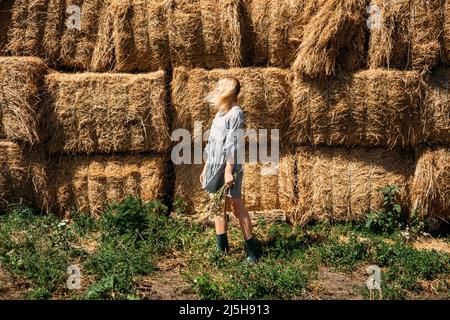 Bauernhöfe und Touren auf dem Bauernhof, Wochenendausflug auf dem Bauernhof Cottagecore. Farm Trips Für Ein Ruhiges Wochenende. Eine Frau in rustikalem Kleid und mit Wildblumen vor Stockfoto