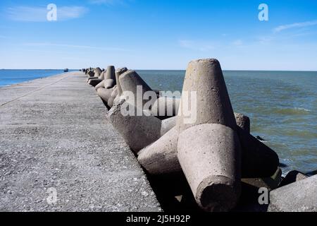 Der Northern Breakwater in Liepaja, eine Nahaufnahme von Tetrapoden und plätschernden, plätschernden Wellen. Dolosse Struktur in der Ostsee Stockfoto