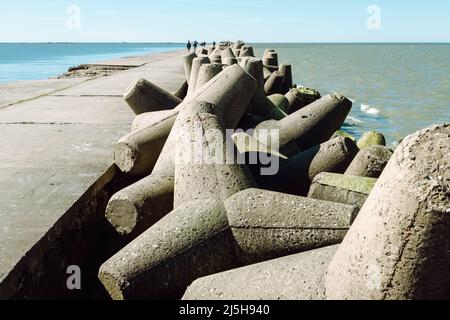 Der Northern Breakwater in Liepaja, eine Nahaufnahme von Tetrapoden und plätschernden, plätschernden Wellen. Dolosse Struktur in der Ostsee Stockfoto
