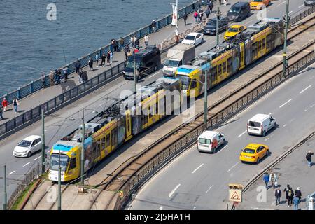 Die Kabatas-Straßenbahn fährt am 8. April 2022 an einem sonnigen Frühlingstag in Istanbul, Türkei, über die Galata-Brücke, die das Goldene Horn überspannt. Stockfoto